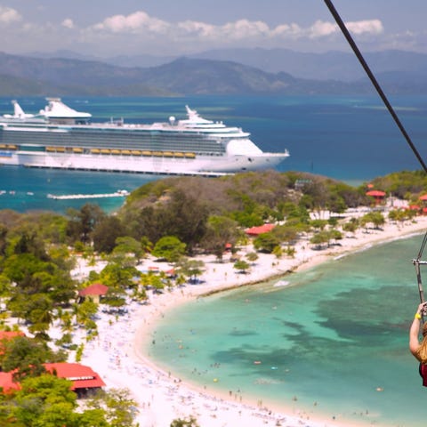 A passenger ziplines in Labadee with a Royal Carib