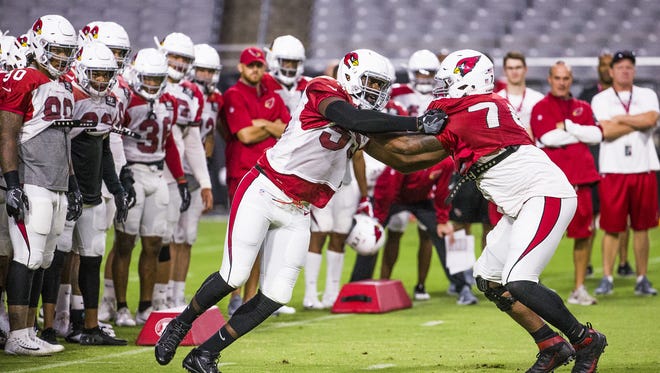 Defensive end Chandler Jones, left, and offensive lineman D.J. Humphries, right, go at it in one-on-one drills at Cardinals camp.