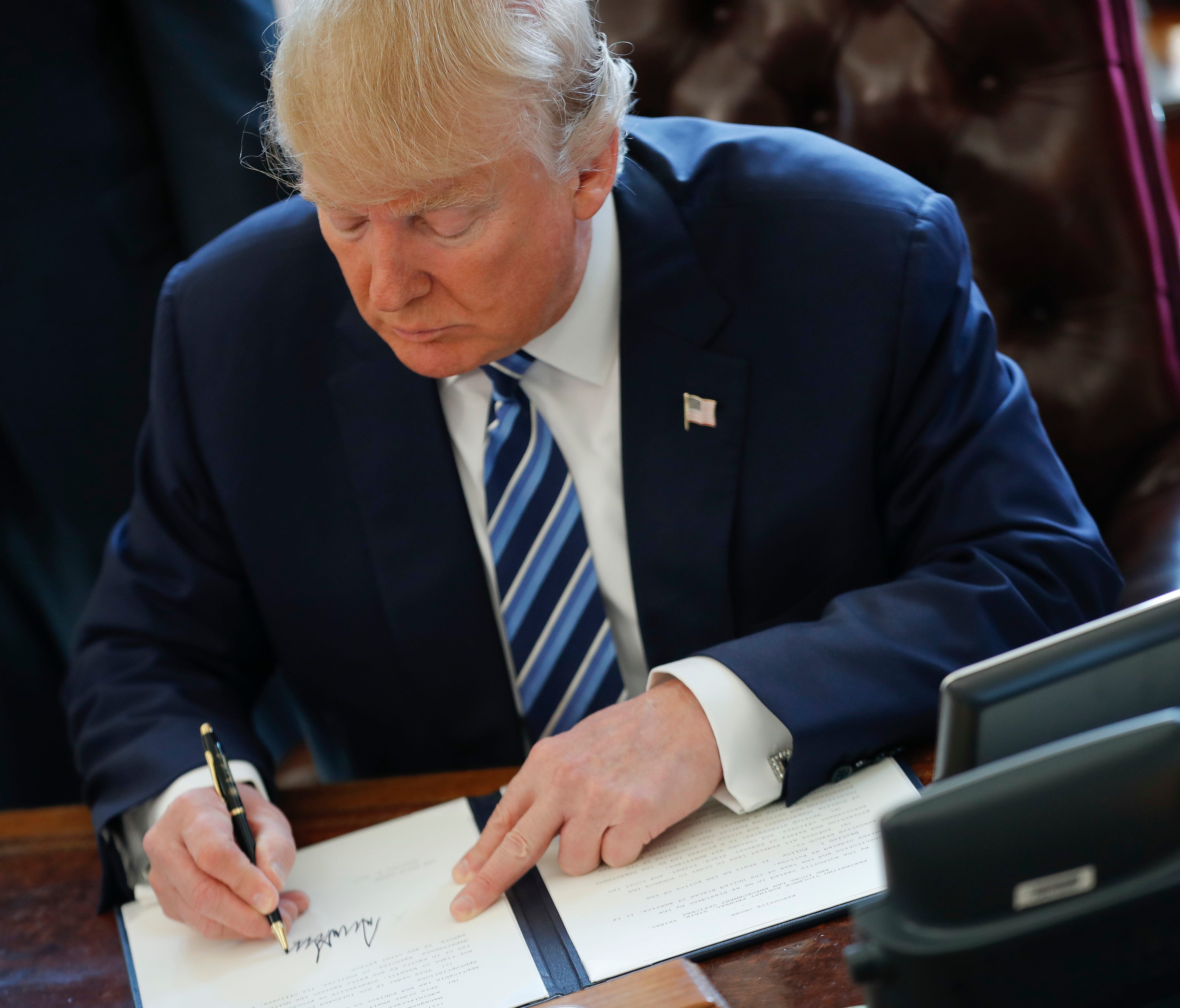 President Trump signs an executive order in the Oval Office on Feb. 9, 2017. Trump signed three executive orders related to reducing crime.