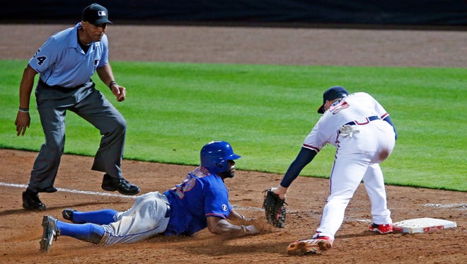 The Mets' Eric Young Jr., left, is tagged out by Atlanta Braves first baseman Freddie Freeman while trying to get back to first base after being caught in a rundown in the fifth inning in Atlanta on Wednesday.