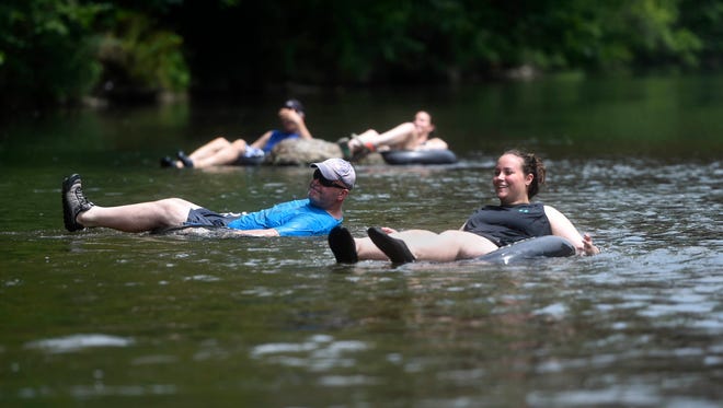 Rachel Coler, right, and Bill Coler of North Lima, Ohio, tube along Yellow Breeches Creek in Upper Allen Township. Tubers, kayakers and swimmers all mingle in this spot near the covered bridge on the Messiah College campus.