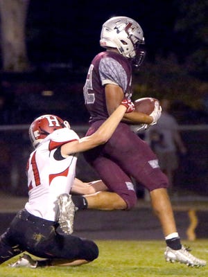 Menomonee Falls' Julius Davis drags Sussex Hamilton's James Hayden with him into the endzone for a touchdown at home on Sept. 25.