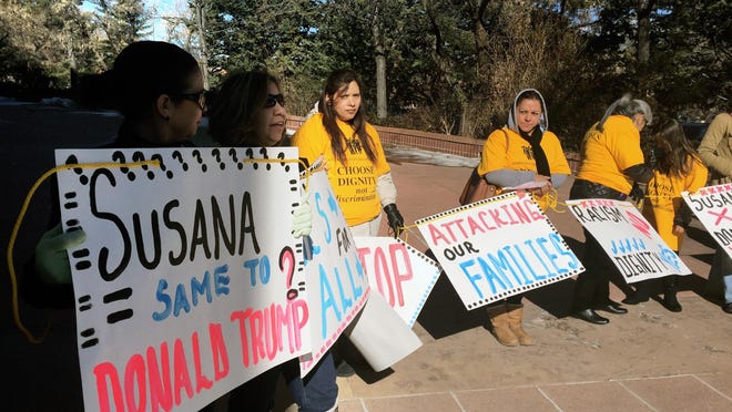 Demonstrators from the Santa Fe-based immigrant advocate group Somos Un Pueblo Unido hold signs outside the capitol in Santa Fe on Tuesday to protest Gov. Susana Martinez’s attempt to revise the state’s immigrant driver’s license law.