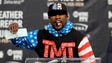 Floyd Mayweather holds up a check while speaking during