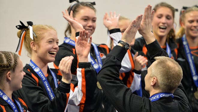 Tech head coach Joel Stark-Haws celebrates the first place win with his team at the Class 2A state high school state gymnastics team championship meet.