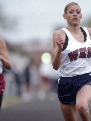West High School's Tyangela Sanders speeds past Oak Ridge High School's Azure Howard to win the 100 meter dash in April 1998.