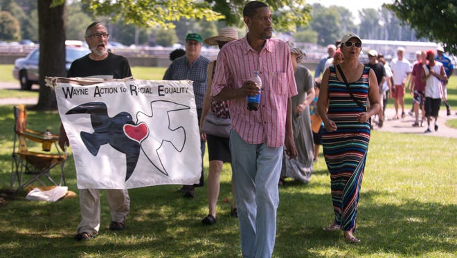 Howard Eagle of Rochester leads the "Take it Down" march around the Ontario Beach carousel, which contains the objectionable piece of art, on Aug. 16, 2015.