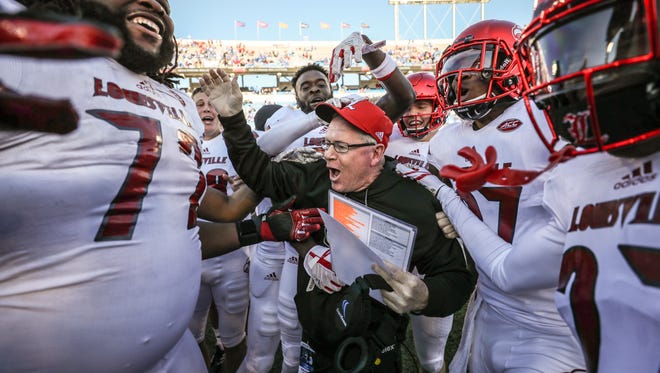 Louisville players celebrate with Bobby Petrino after Louisville defeated Kentucky 44-17.November 25, 2017