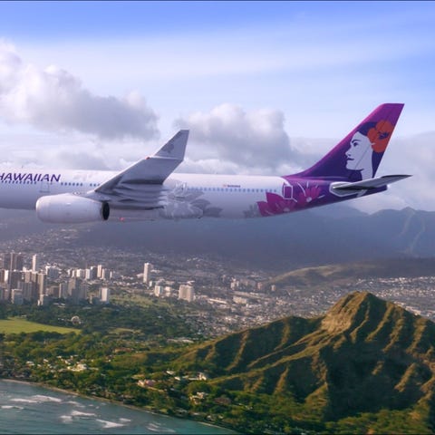 A Hawaiian Airlines plane flies over Diamond Head.
