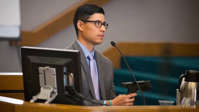 Former Santa Fe County sheriff’s deputy Tai Chan, on trial for murder at Las Cruces District Court, holds the gun he used to kill fellow deputy Jeremy Martin in October 2014. Chan, who took the witness stand on June 3, 2016, is alleging he shot Martin in self defense.