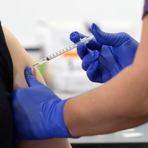 A nurse administers the first of the two Pfizer-Bi