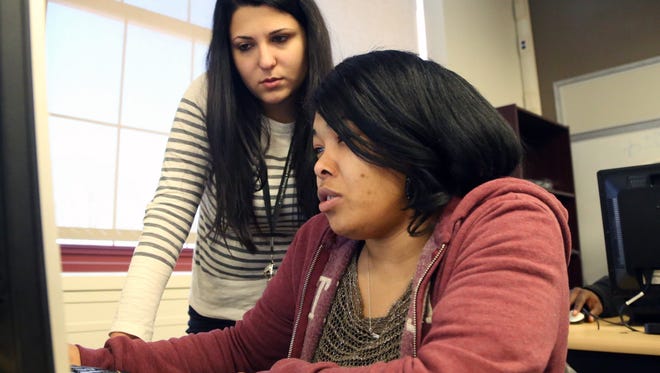 Dima Walters helps Elizabeth Abrams, 38, during GED classes at the Adult Education Center-West Campus in Detroit earlier this month. “I want to be an inspiration to other people that you’re never too old and it’s never too late to try and go back and get your GED,” Abrams said.