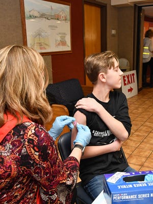 Tracy Giarla, Marblehead Public Health Nurse, gives a flu shot to Sam Patterson during the North Shore Flu Clinic sponsored by the North Shore Public Health Nurse's at the Danvers YMCA in 2018. State officials are requiring all students receive a flu shot by the end of 2020.
