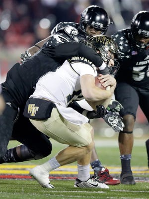 Wake Forest quarterback John Wolford takes one of seven sacks in last month's game against Louisville.