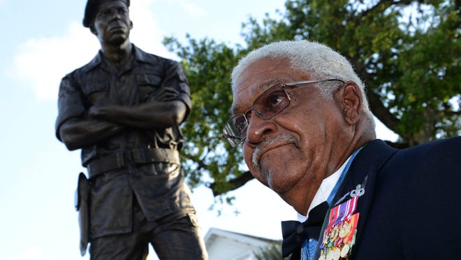 Medal of Honor recipient Melvin Morris stands in front of a statue of himself that was unveiled in Cocoa's Riverfront Park on Thursday evening.