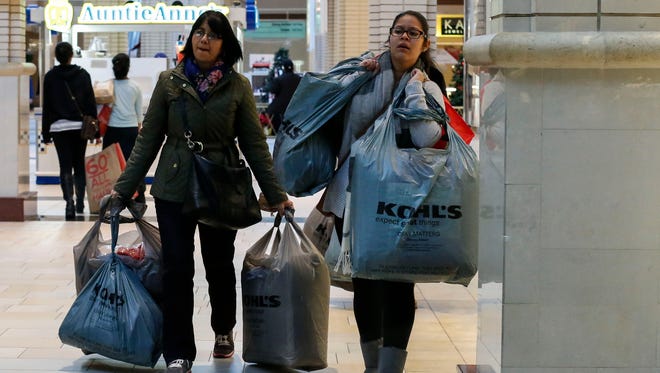 JERSEY CITY, NJ - NOVEMBER 27: Customers carry shopping bags at the Newport Mall during Black Friday Sales on November 27, 2015 in Jersey City, New Jersey.  It was expected that 135.8 million Americans would shop this Black Friday weekend, according to the National Retail Federation .(Photo by Kena Betancur/Getty Images)