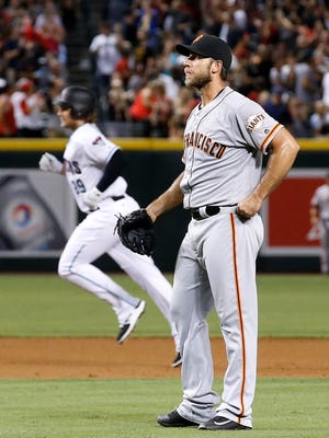 San Francisco Giants' Madison Bumgarner, right, waits for a new baseball after giving up a two-run home run to Arizona Diamondbacks' Kyle Jensen (29) during the third inning of a game Friday, Sept. 9, 2016, in Phoenix.