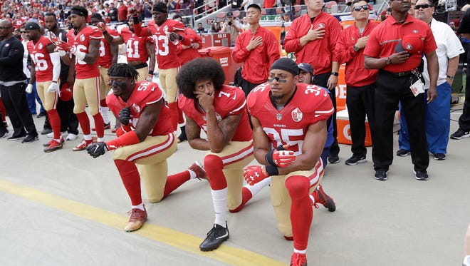 San Francisco 49ers outside linebacker Eli Harold, left, quarterback Colin Kaepernick, center, and safety Eric Reid kneel during the national anthem before an NFL football game against the Dallas Cowboys in Santa Clara, Calif., Sunday, Oct. 2, 2016. Many believe kneeling or sitting during the pre-game anthem is disrespectful and has sparked a heated national debate.
