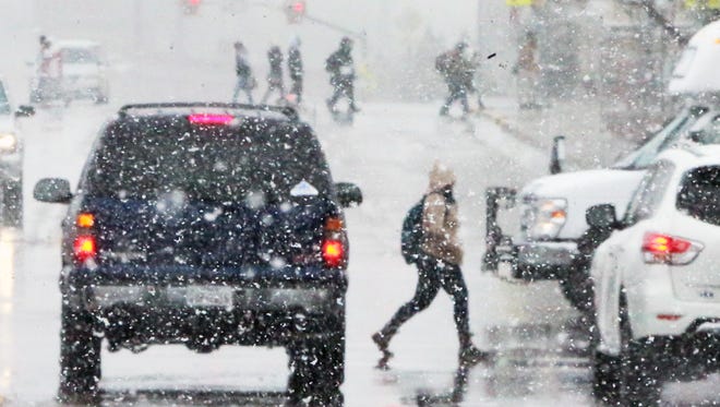 Wintery Scene: UTEP students cross Schuster Ave. amid falling snow Thursday, Dec. 7.