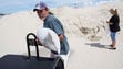 Donald Buckley loads a sandbag into a golf cart at
