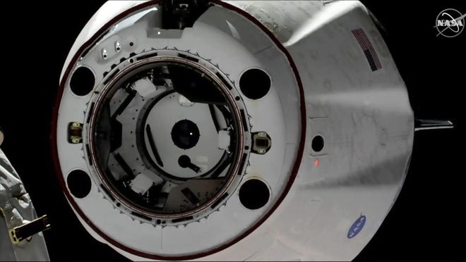 In this image taken from NASA Television, SpaceX's swanky new crew capsule undocks from the International Space Station, left, March 8, 2019. The capsule undocked and is headed toward an old-fashioned splashdown. The Dragon capsule pulled away from the orbiting lab early Friday, a test dummy named Ripley its lone occupant.