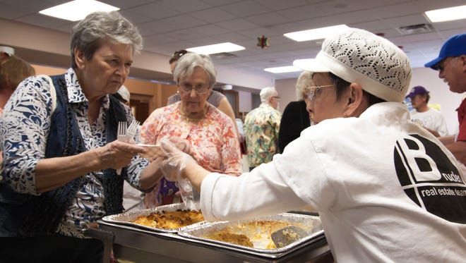 Volunteer Marianne Rosenthan, right, serves kugel to Marleme Lavetts, left, and Nancy Jenkins during a previous Jewish Food and Folk Festival on Sunday at Temple Beth-El.