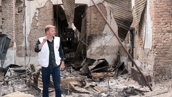 In this Friday, Oct. 16, 2015 photo, Christopher Stokes, the general director of the medical charity, Doctors Without Borders, which is also known by its French abbreviation MSF, stands amid the charred remains of the organization's hospital, after it was hit by a U.S. airstrike in Kunduz, Afghanistan.