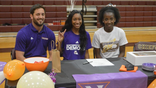 Natchitoches Central sprinter Jasmine Hall (center) flashes the "Fork 'Em Demons" sign after signing with Northwestern State Thursday.