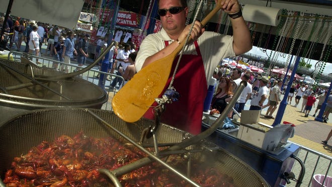 Vaughn Womack stirs some boiling crawfish during the 2002 Mudbug Madness festival. Shaver's Catering had both of these pots cooking 120 lbs each.