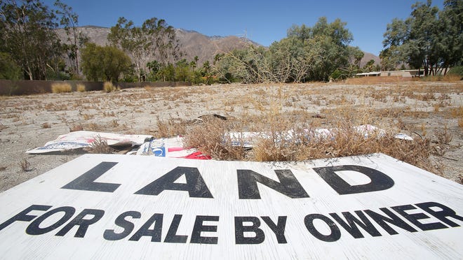 A for sale sign lays in a empty parcel of land on Palm Canyon Dr. and Stevens Rd. in Palm Springs, Monday, May 18, 2015.
