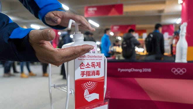 A man sanitizes his hands at the entrance to the media cafeteria in Gangneung, South Korea, Wednesday, Feb. 7, 2018. South Korean authorities deployed 900 military personnel at the Pyeongchang Olympics on Tuesday after the security force was depleted by an outbreak of norovirus.