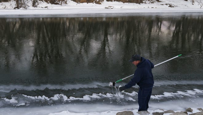 Bill Blubaugh, lab technician with Des Moines Water Works, collects water samples Thursday, Jan. 15, 2015 at multiple points along the Raccoon River in Des Moines.