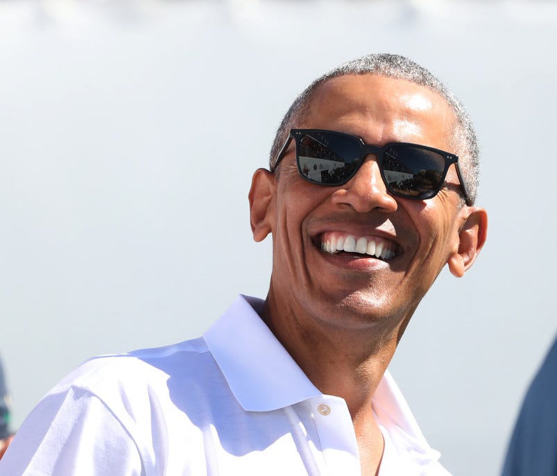 Former president Barack Obama flashes a smile during the first round foursomes match of The President's Cup golf tournament in September
