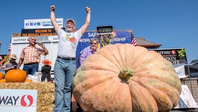 Joel Holland throws his arms into the air after winning the 44th World Championship Pumpkin Weigh-Off in Half Moon Bay, CA., with his 2,363 pound pumpkin.