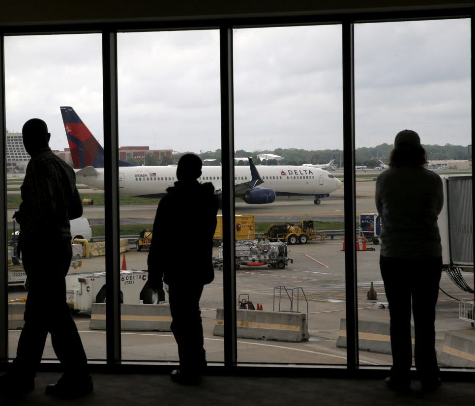 Delta Air Lines passengers watch April 14, 2015, as a plane taxis at Atlanta's Hartsfield-Jackson International Airport.