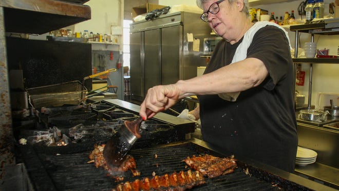 Connie Strassburg, who owns Memphis Pig Out with her husband Mark, cooks a half chicken, baby back ribs and spare ribs on the grill in this 2014 photo.

081114  Tom Spader/Asbury Park Press