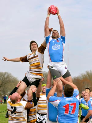 The St. Cloud Bottom Feeders, in blue, catch the rugby football over the Winnipeg Wombats on Saturday during a line-out at the 29th Annual All-Saints Rugby Tournament at Selke Field. More than 700 players participated in the two-day event. A line-out happens when the ball goes out of touch or off the playing field.