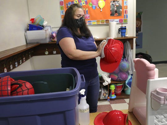Preschool teacher Juila Teets cleans toys at the Play and Learn Christian Child Care Center in Clintonville on Thursday in preparation for the center's reopening. It will serve 30 fewer kids to stay under limits on class sizes and caregiver-to-child ratios.