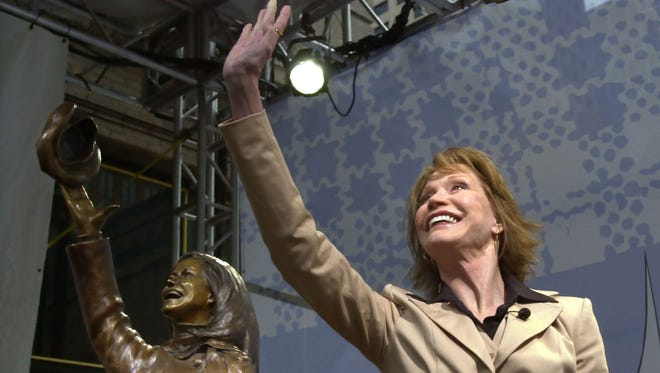 Mary Tyler Moore is mirrored by a bronze statue of herself after the unveiling of the statue capturing her flinging her tam as she did in the opening for her 1970s television hit, "The Mary Tyler Moore Show" in Minneapolis, May 8, 2002.
