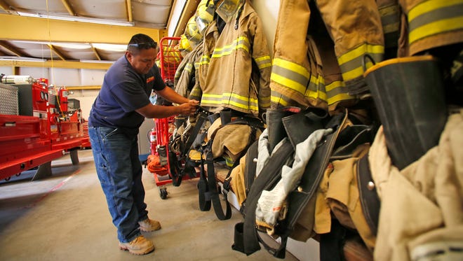 Volunteer firefighter Wilbert Atene checks his gear at District 12, Shiprock Station 1.