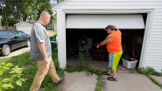 Bill Paape, community investment manager for the city of Green Bay, left, is shown a place frequented by rats by Keith Hendzel near his home in the 800 block of Howard Street Thursday, June 21, 2018 in Green Bay, Wis.