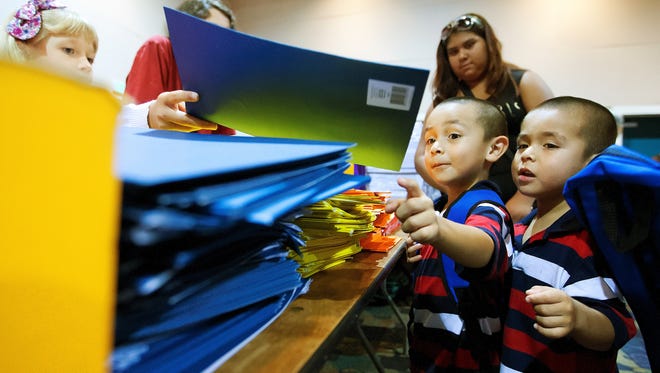 Colonial Elementary School kindergarteners Alfredo Solis, 5, and his twin brother Adan were among those who received school supplies Sunday at the Big Backpack Event at the Harborside Event Center in downtown Fort Myers.