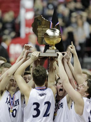 Xavier players celebrate with the trophy after the Division 3 championship game against Prescott on Saturday at the Kohl Center in Madison. See more photos at postcrescent.com.