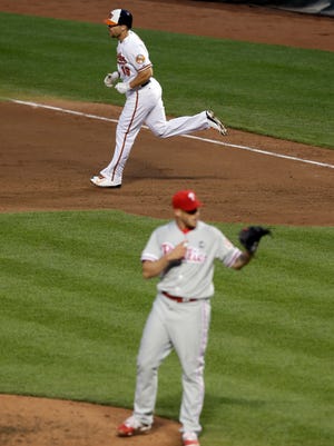 Chris Davis rounds the bases past Phillies relief pitcher Dustin McGowan after hitting a solo home run in the fourth inning.