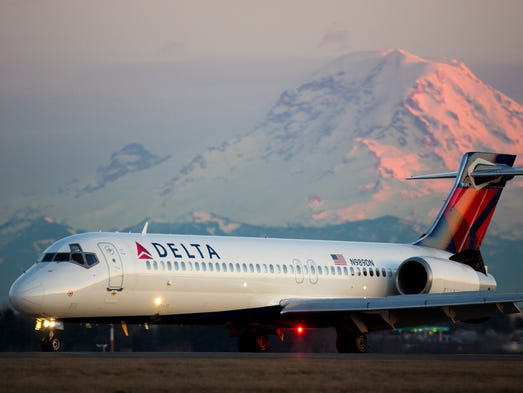 Mount Rainier looms in the background as a Delta Air