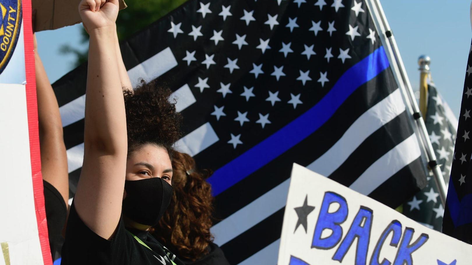 A Black Lives Matter supporter raises her fist in solidarity amid a crowd of "Back the Blue" rally goers in this file photo from the Topeka, Kansas Capital-Journal newspaper.
