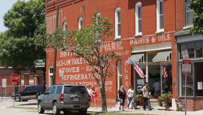 In this June 27, 2013 photo, people walk past The Tavern in the Brady Arts District in Tulsa, Okla. After a three-hour public hearing, Tulsa's City Council postponed a vote Thursday night on renaming a popular street named after Wyatt Tate Brady, a town founder who had ties to the Ku Klux Klan and possibly a race riot. (AP Photo/Sue Ogrocki, File)