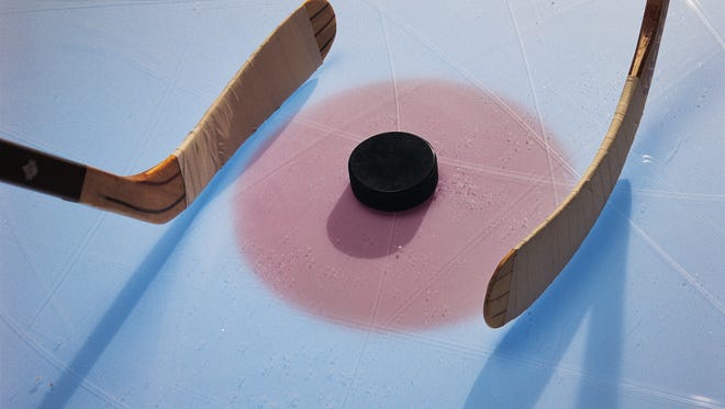 Ice hockey puck and sticks in face-off