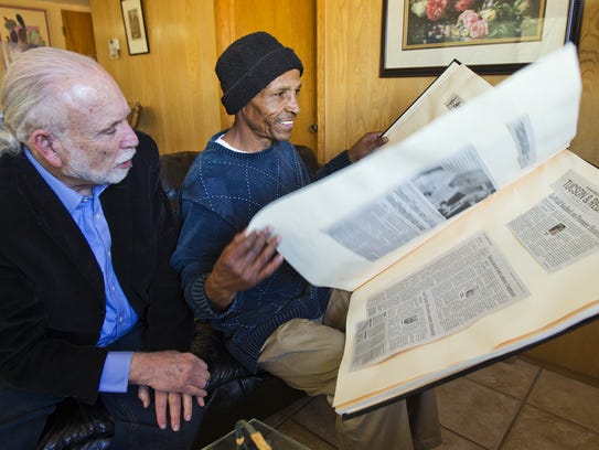In 2013, Louis Taylor (right) looks through a scrapbook
