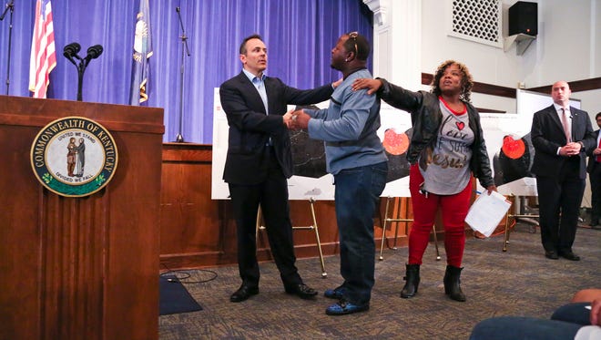 Gov. Matt Bevin shakes audience member Kalvin Brown's hand after the Louisville resident approached the podium during the Kentucky governor's talk about curbing the violence through prayer. Brown said more money was needed as well to provide jobs and start businesses through loans.
